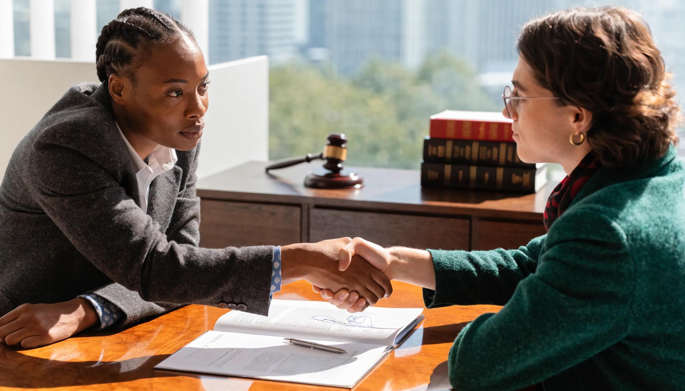 Business professionals shaking hands over a contract representing successful negotiation